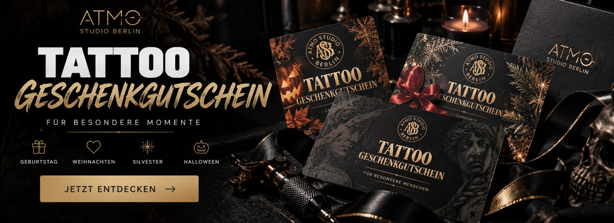 Promotional graphic for ATM0 Studio Berlin tattoo gift certificates, showing several black gift cards with gold and red decorative designs and the text 'TATTOO GESchenkgutschein' on a dark, moody background with candles and ribbons.